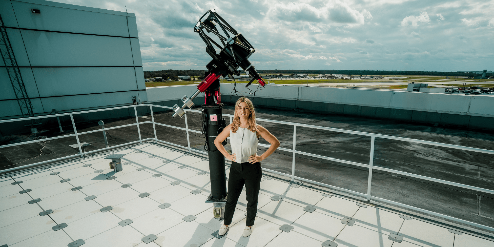 Gwynlyn Hannah poses next to aerospace equipment on Embry-Riddle's Daytona Beach campus.