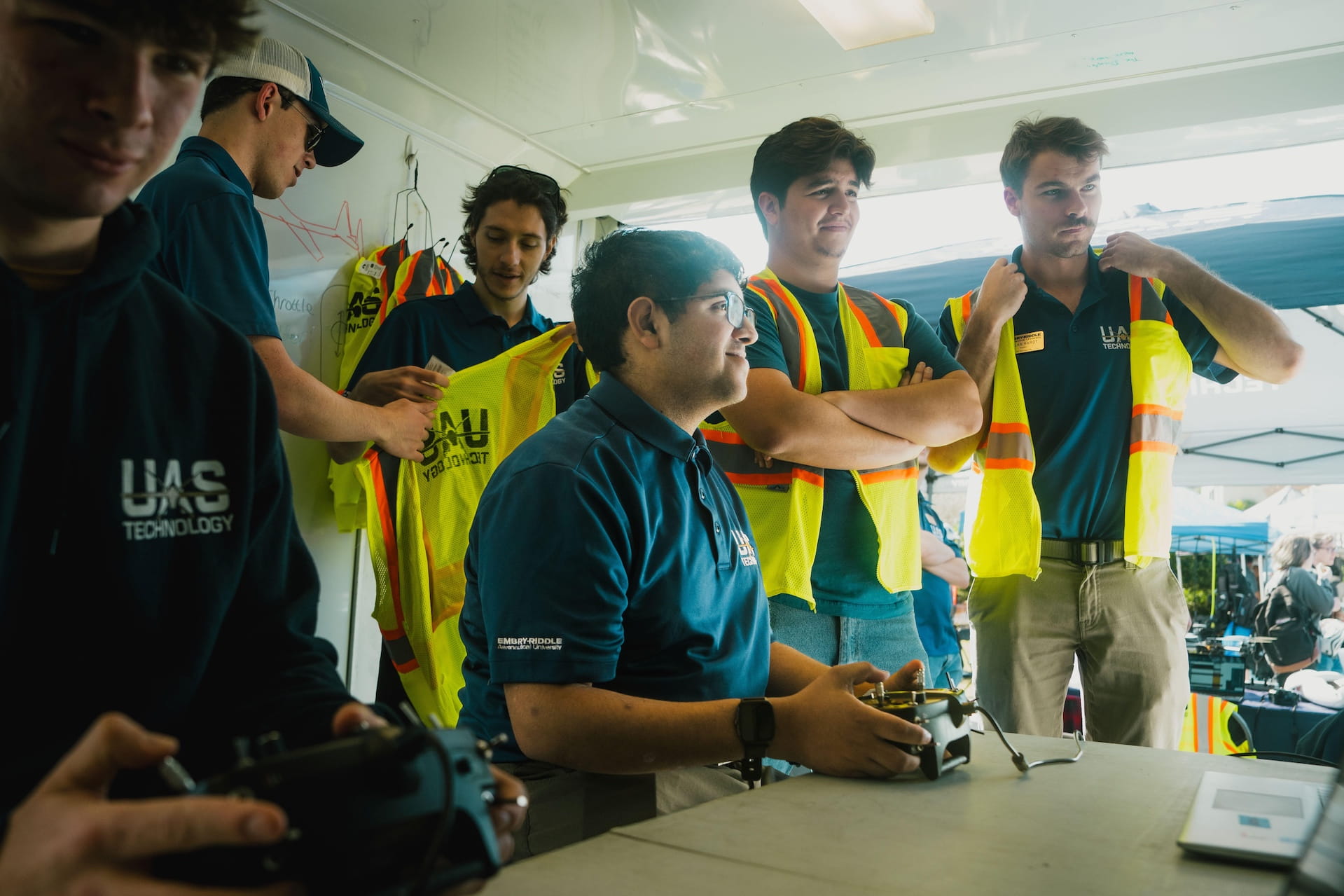 Embry-Riddle student operates and uncrewed aircraft as other students in safety vests observe