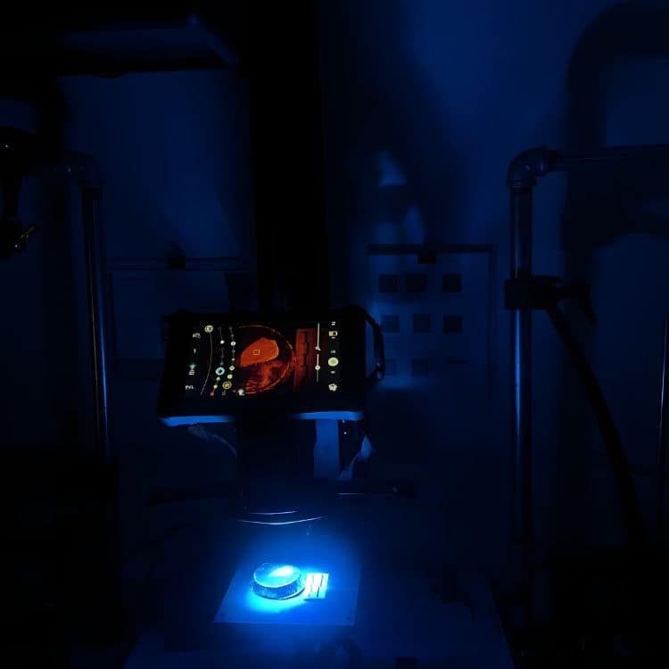 A latent fingerprint is illuminated and examined using the Crime Lite AUTO imaging device during a forensic analysis.