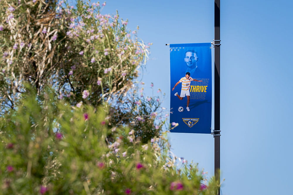 A sports banner featuring Francesco Busini hands on a post on the Prescott campus