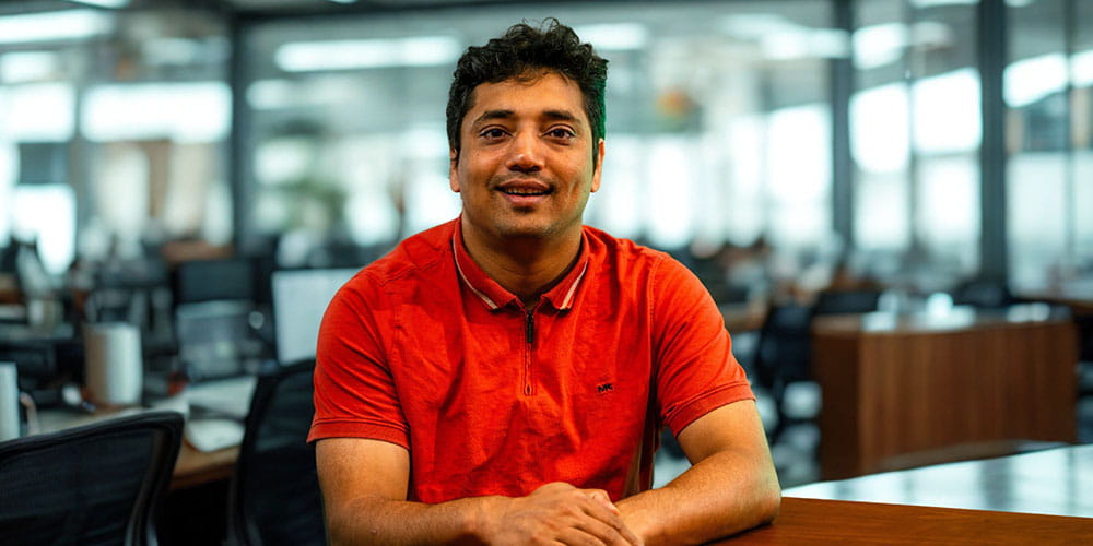 Raju Dhakal sits at a desk in a computer lab