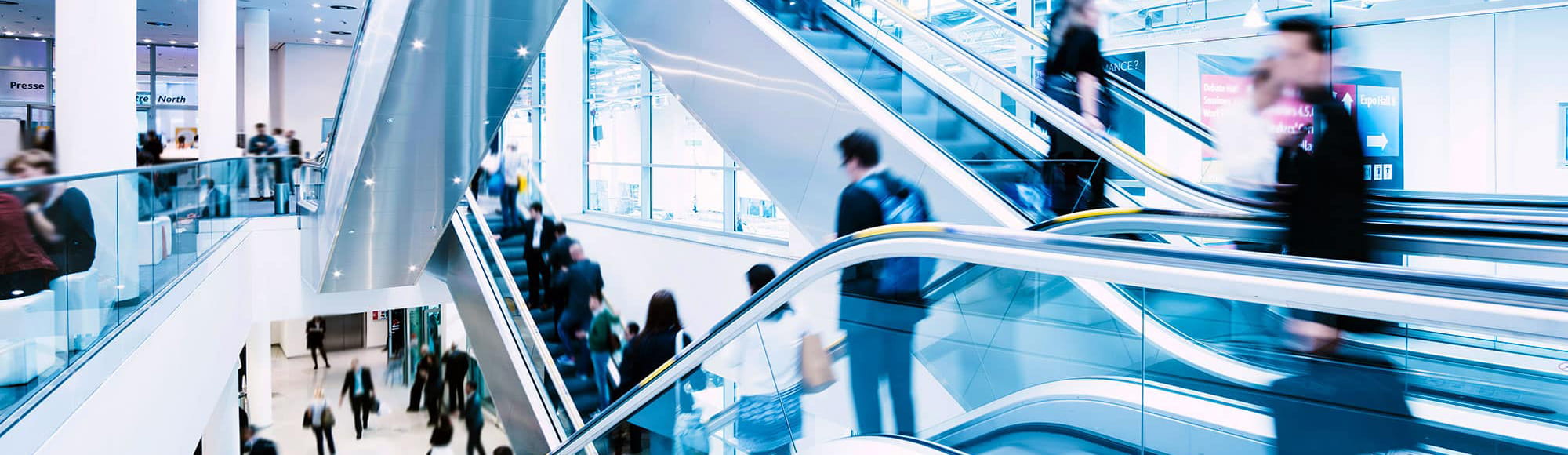 people traveling through an airport via escalators