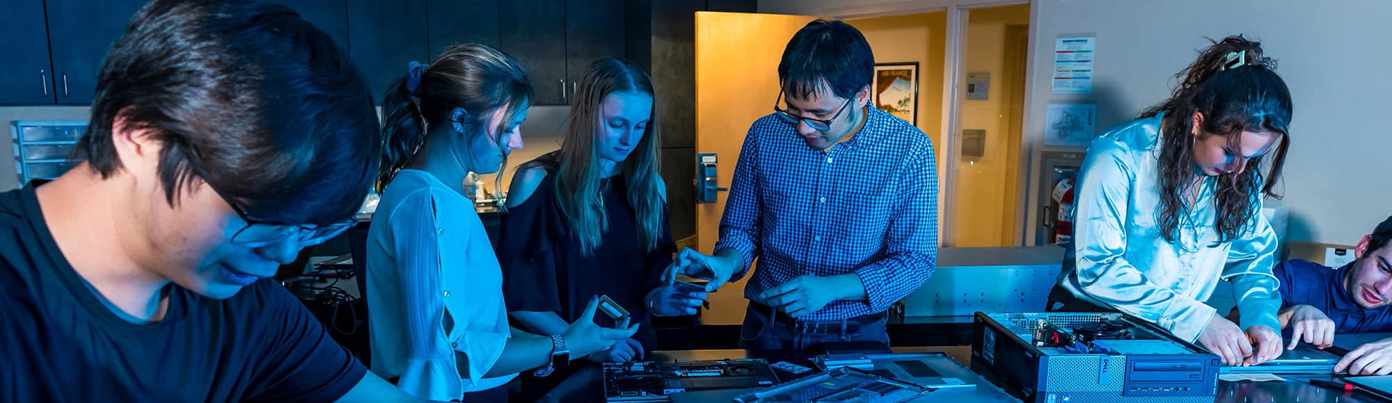 students work around the table building computers