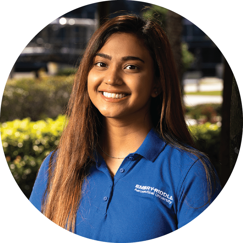 Tahmina Tisha stands outside in an Embry-Riddle polo for a professional headshot