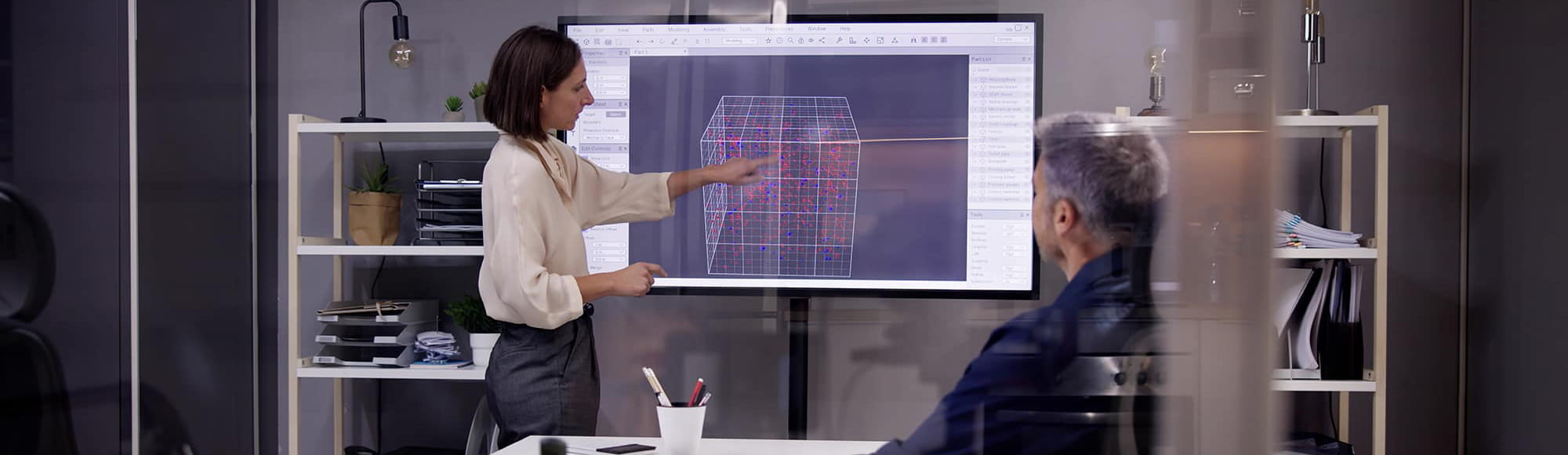 a woman shows a 3d rendering to a group in a conference room
