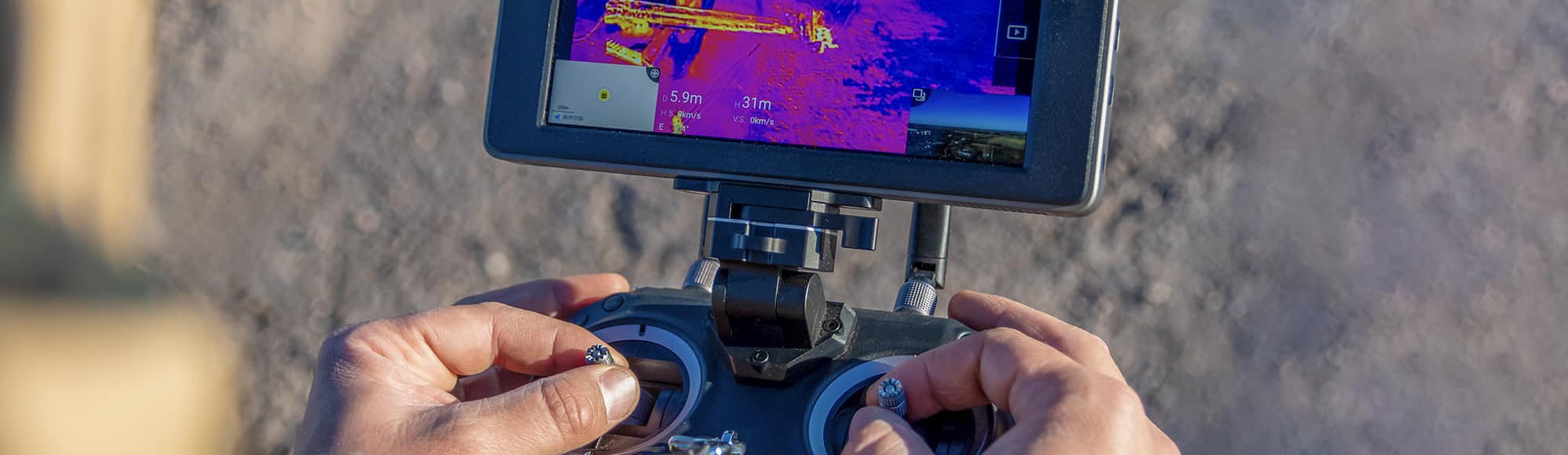 Person uses a remote control with a screen to navigate an uncrewed system