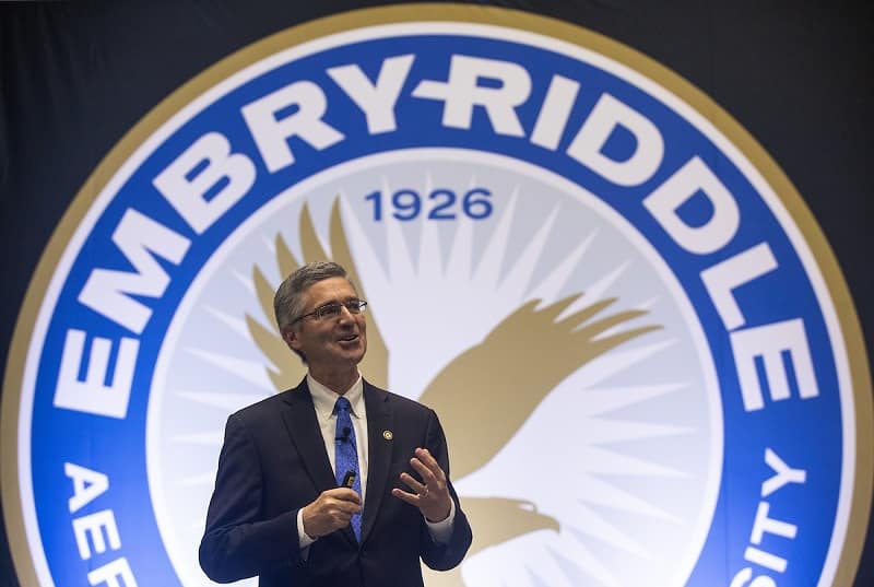 Embry-Riddle President P. Barry Butler stands in front of the university seal at the 2018 State of the University address.