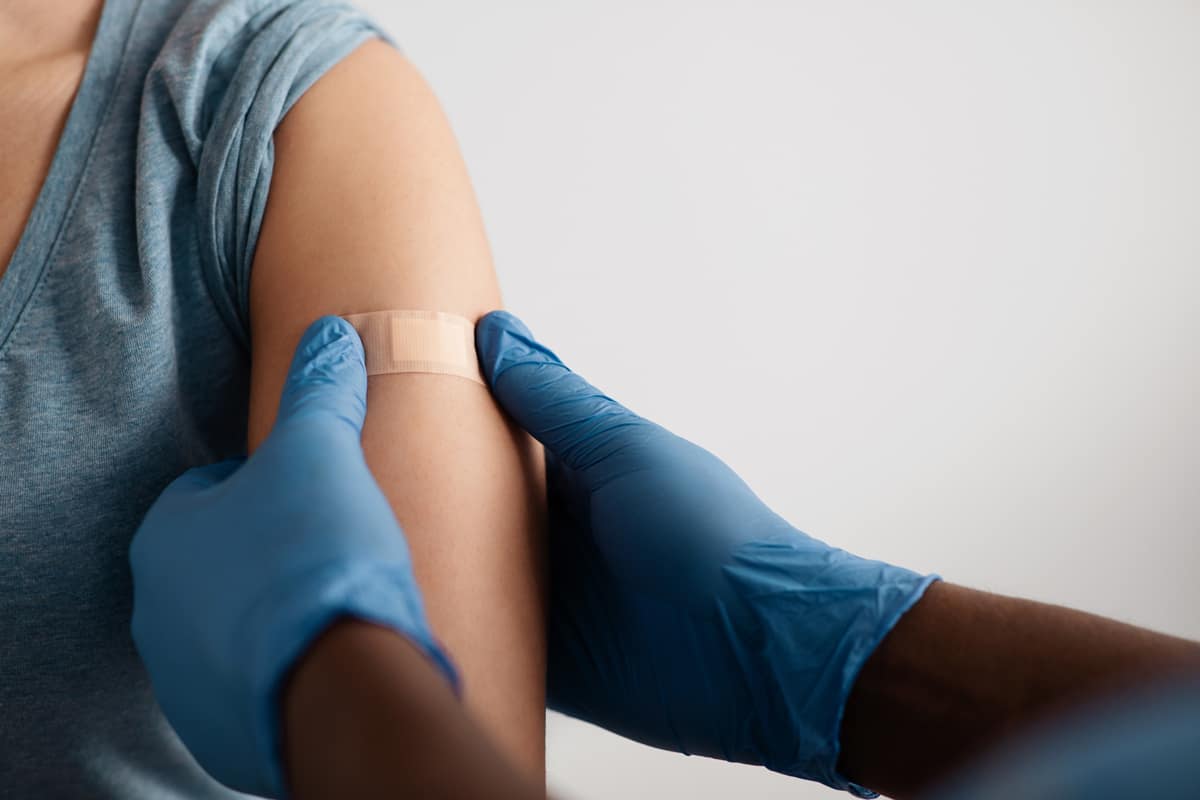 Band-aid over a vaccination on arm.