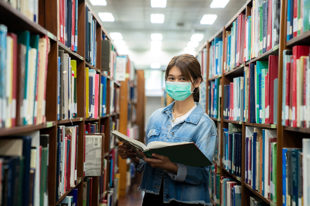 Woman with mask in library