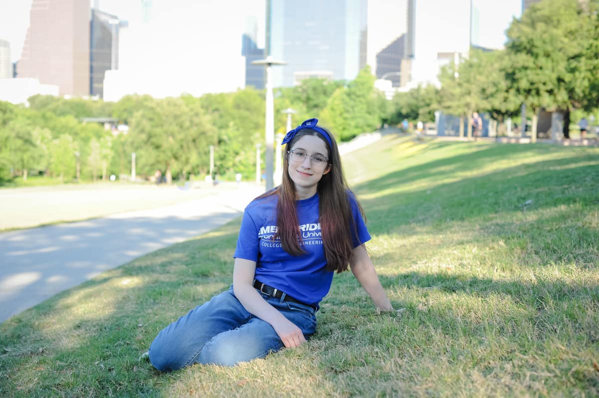 Aerospace Engineering sophomore Lillian Sudkamp sits on grassy hill.