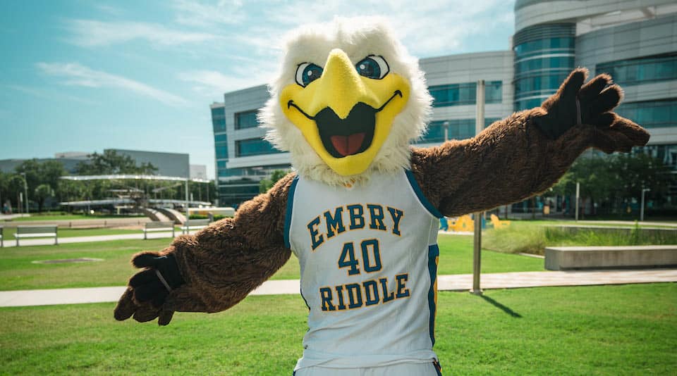 Embry-Riddle mascot Ernie the eagle standing outdoors on a green lawn.