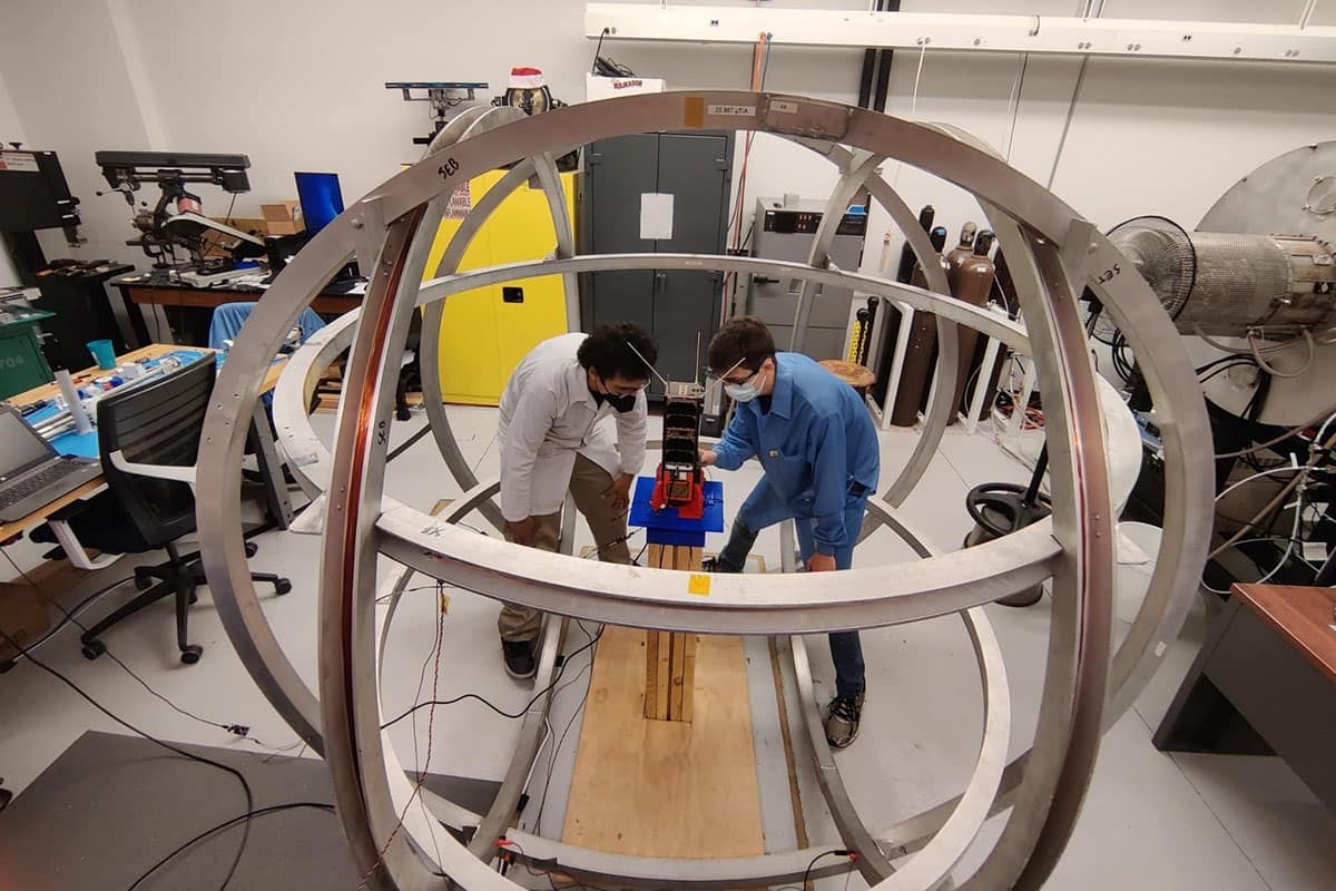 Students work inside a Helmholtz-Cage.