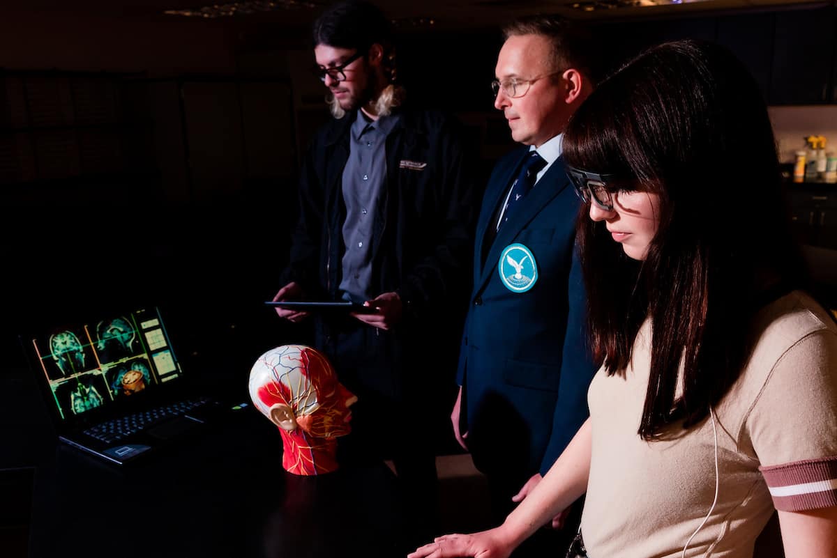 Embry‑Riddle College of Business Security and Intelligence student Nick Hight, professor Stathis Kefallonitis and student Emma Rasmussen compare biometric data based on how emotional reactions affect regions of the brain.