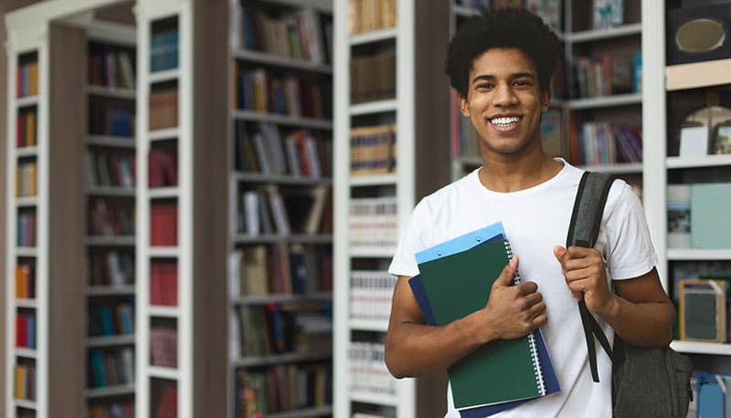 Male student carrying books.