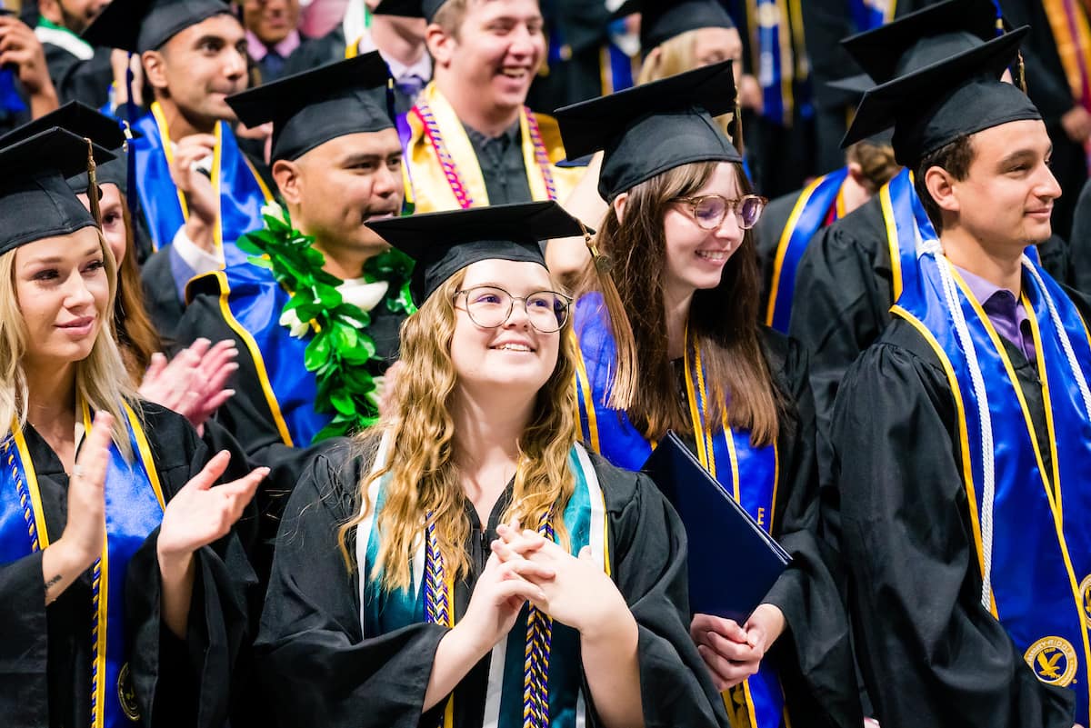 Students in cap and gown at graduation ceremony.