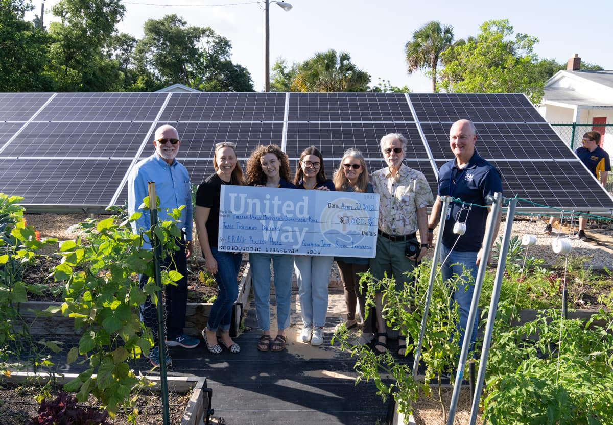 Students with garden and solar panel project.