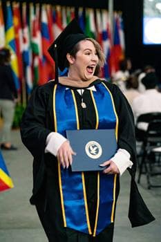 A woman walks at a graduation.