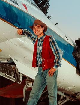 Man poses next to a plane