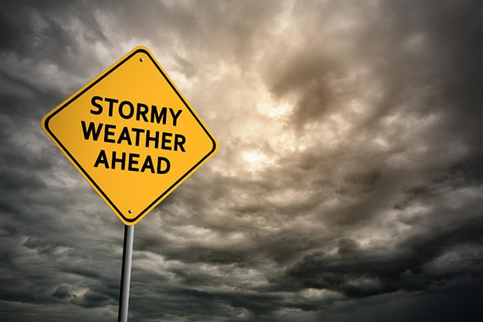 Street sign that says Stormy Weather Ahead in front cloudy skies.