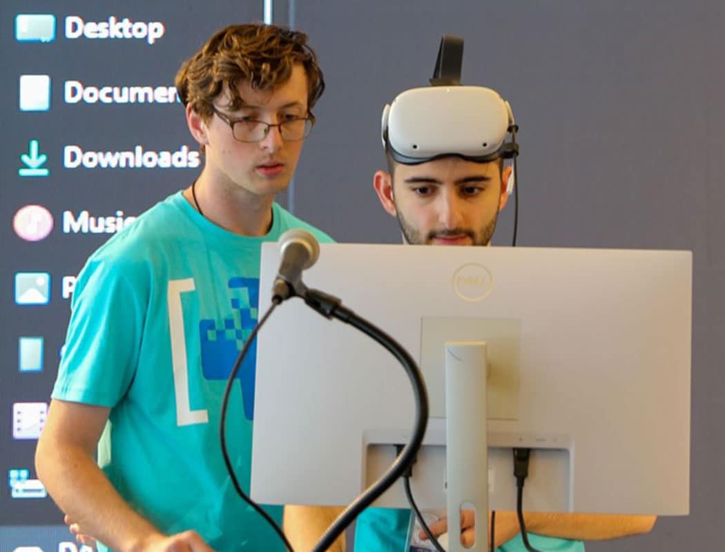 Two students look at VR monitor.