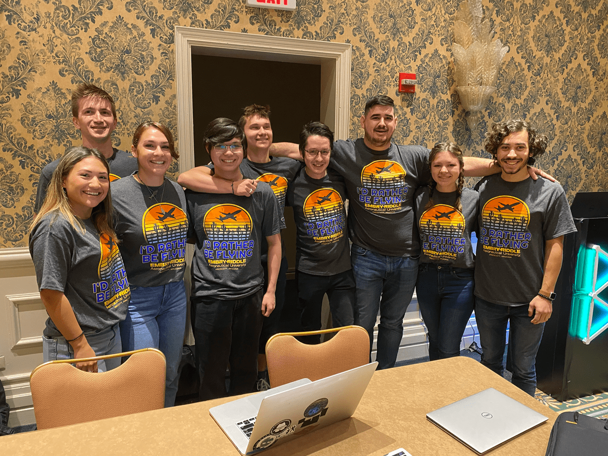 Group of students pose for picture in hotel conference room.