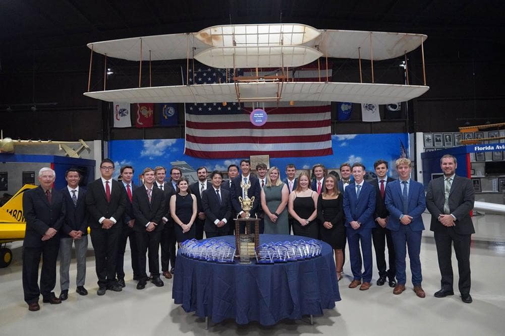The Golden Eagles Flight Team from Embry‑Riddle’s Daytona Campus stands behind table displaying awards.