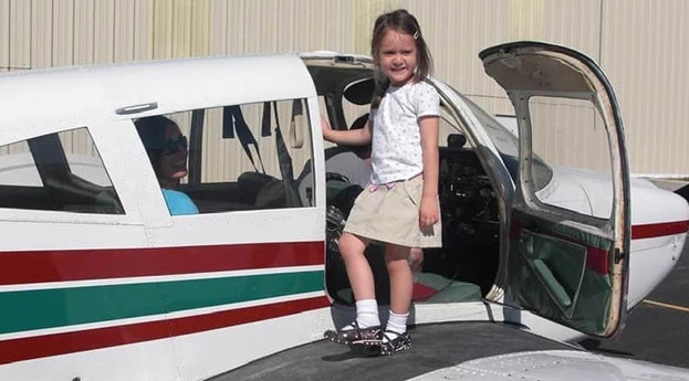 Michelle Tabor as a girl standing on a plane wing