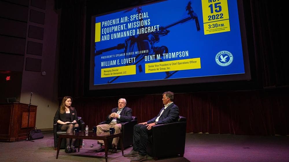 Three people sit on a stage having a discussion.