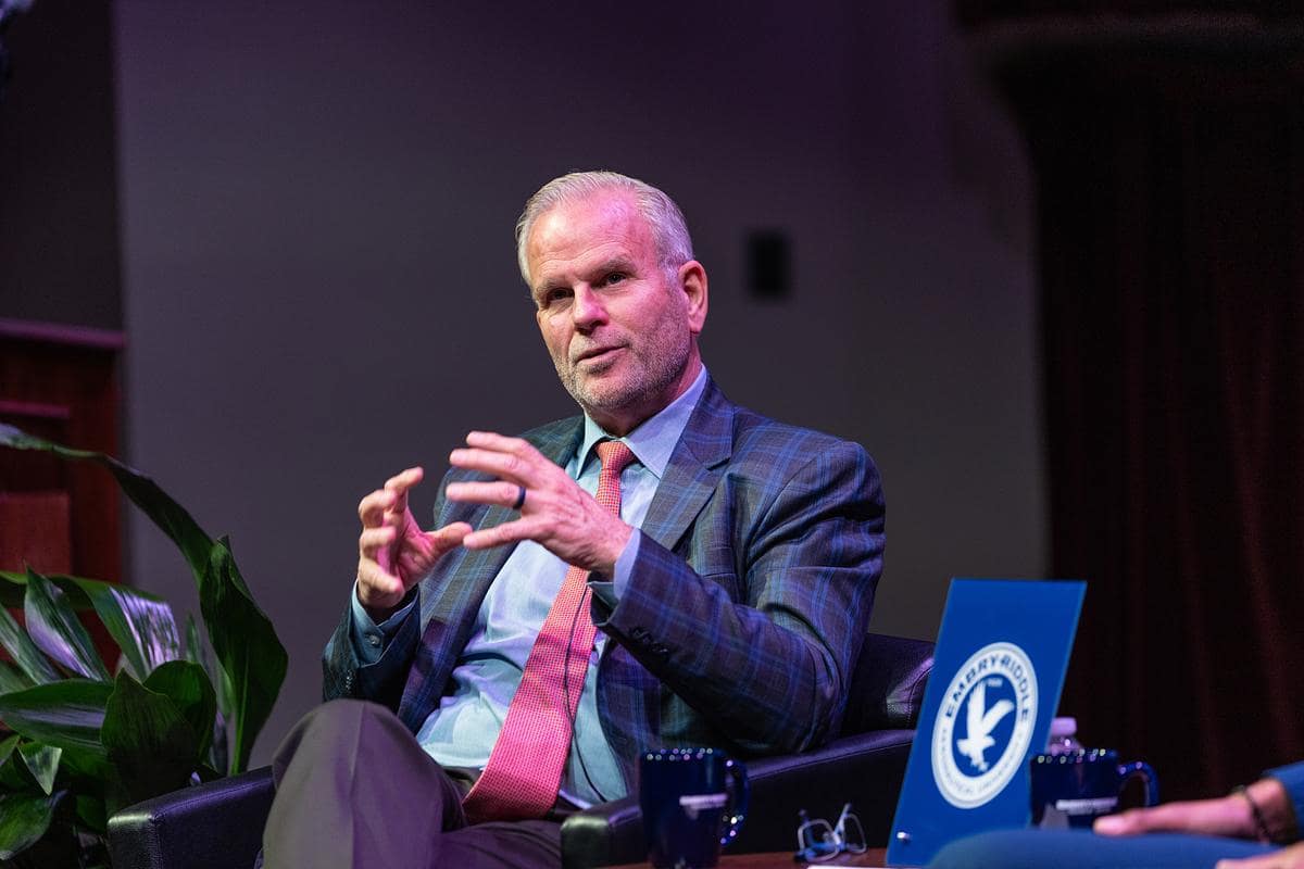Dan Elwell sits on stage talking to audience.