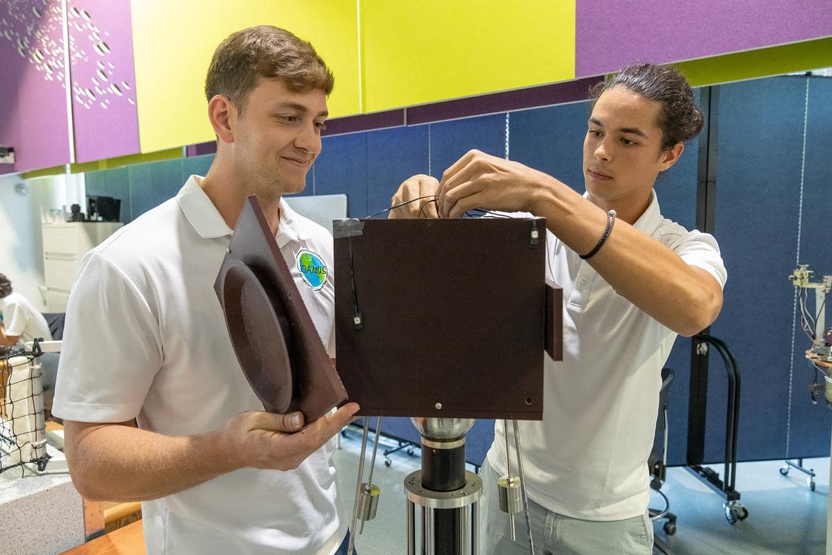 Two students work on model spacecraft.