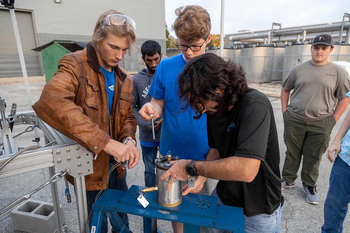 Students work on rocket fuel feed system at launch site.