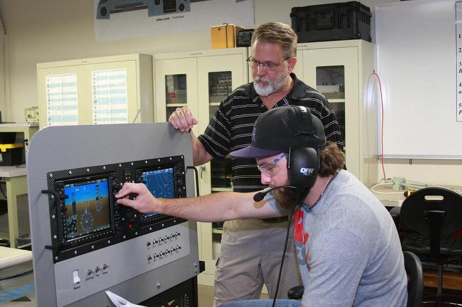 Professor Neil Fulbright, director of Avionics & Cybertechnology at Embry‑Riddle’s Daytona Beach Campus, works with an aviation line maintenance student in the Avionics Laboratory. (Photo: Embry‑Riddle/Chris Carta) Professor Neil Fulbright works with a student.