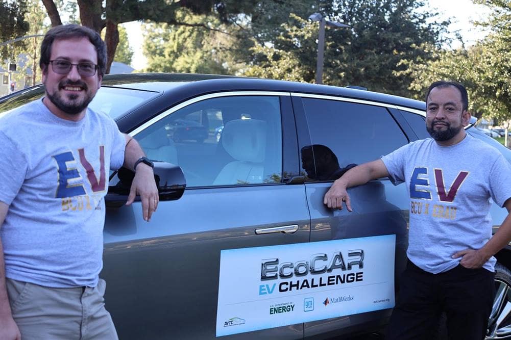 Two members of EcoCAR EV Challenge team poses in front of electric car.