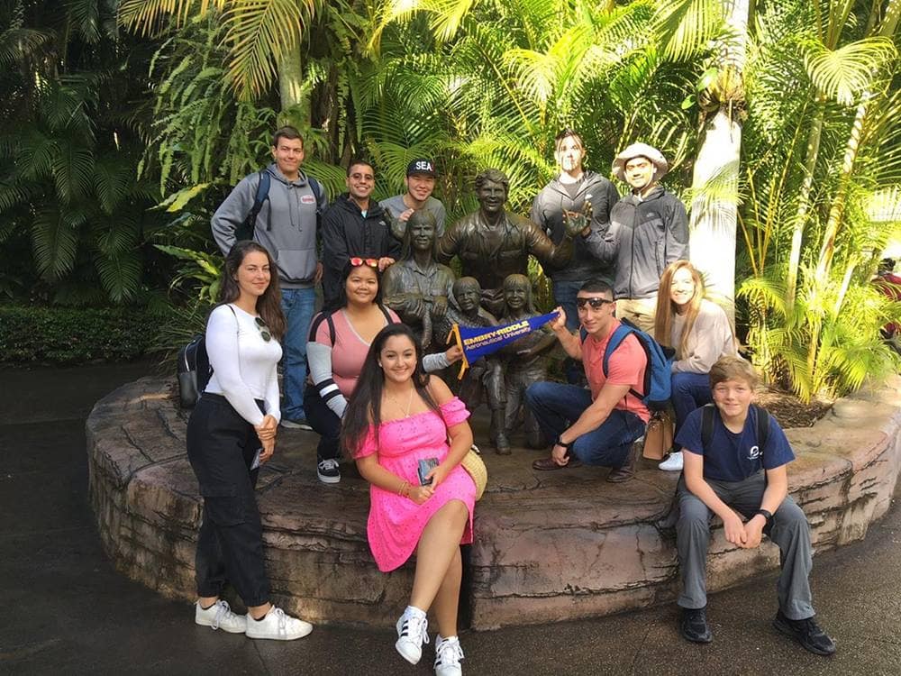 Students pose for picture in front of statue in Queensland.