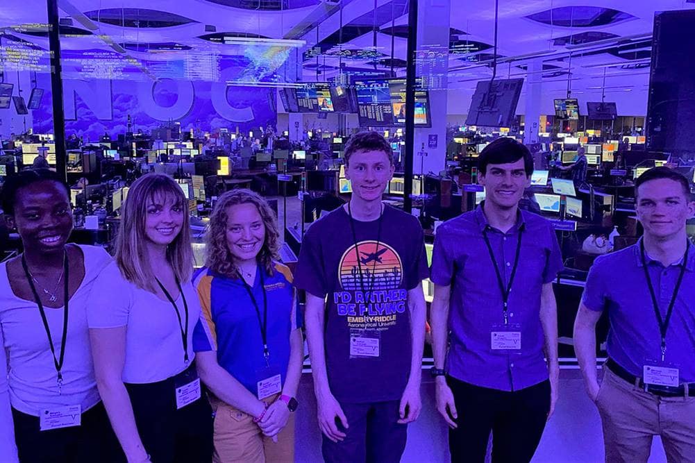 A group of college students tour airline operations center.