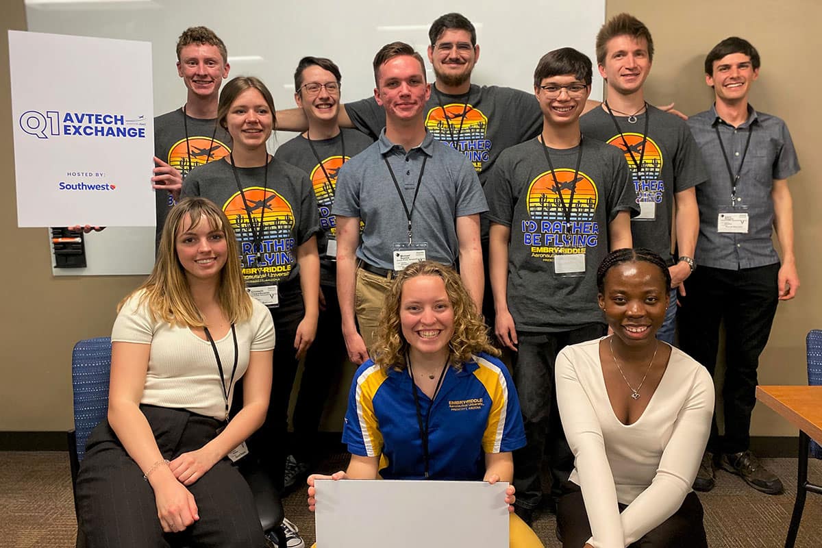 A group of college students poses in classroom.