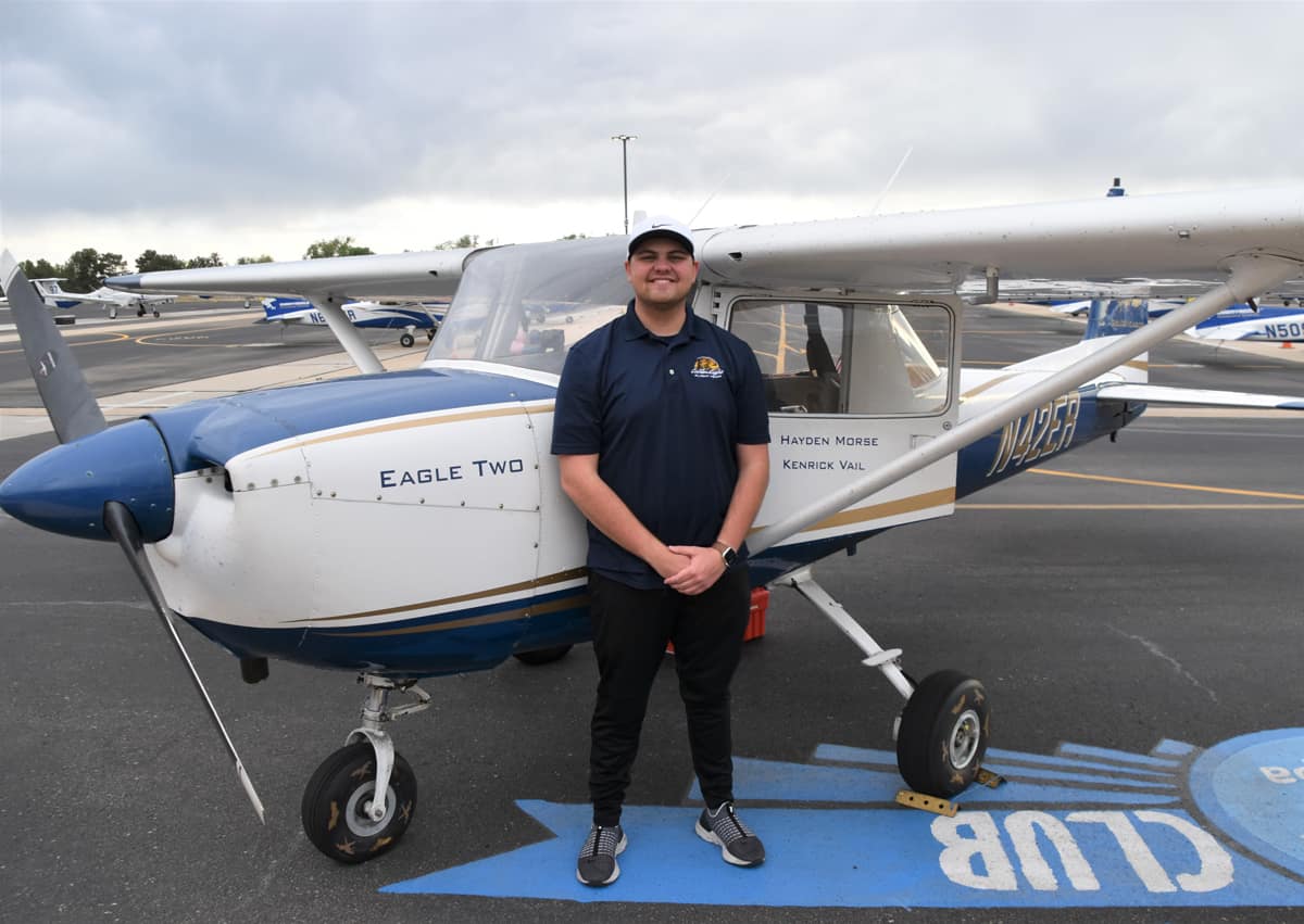 Man stands in front of airplane.