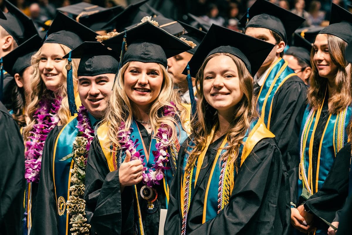 Multiple college graduates pose for picture.