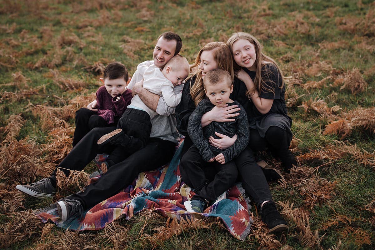 Family of six taking picture in field.