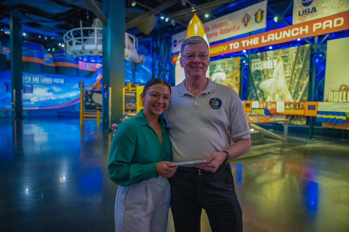 Woman and man pose for picture in Kennedy Space Center.
