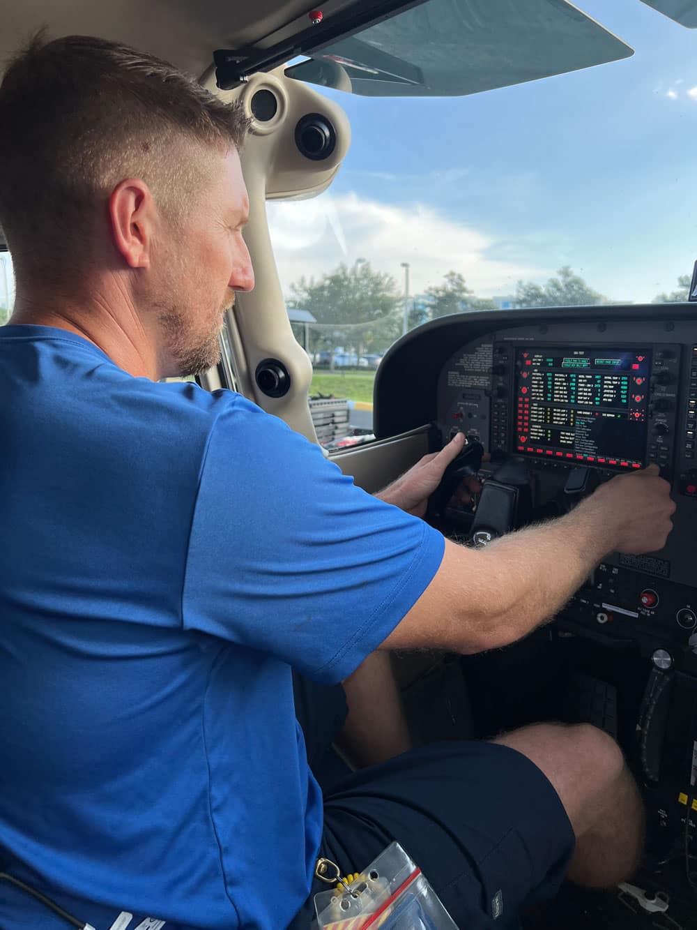 Man works on airplane mechanics outdoors.