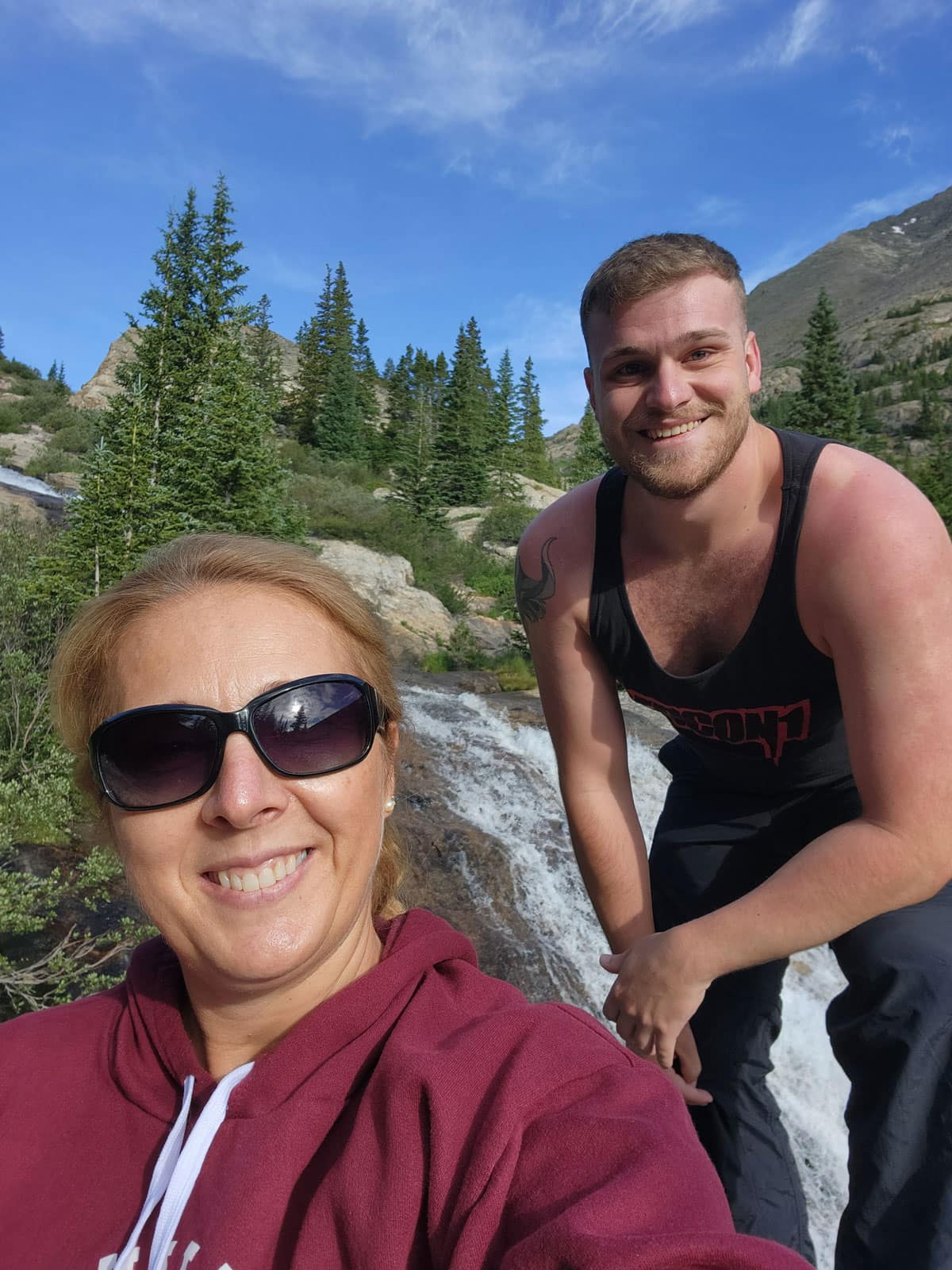 Man and woman pose on hiking trail.