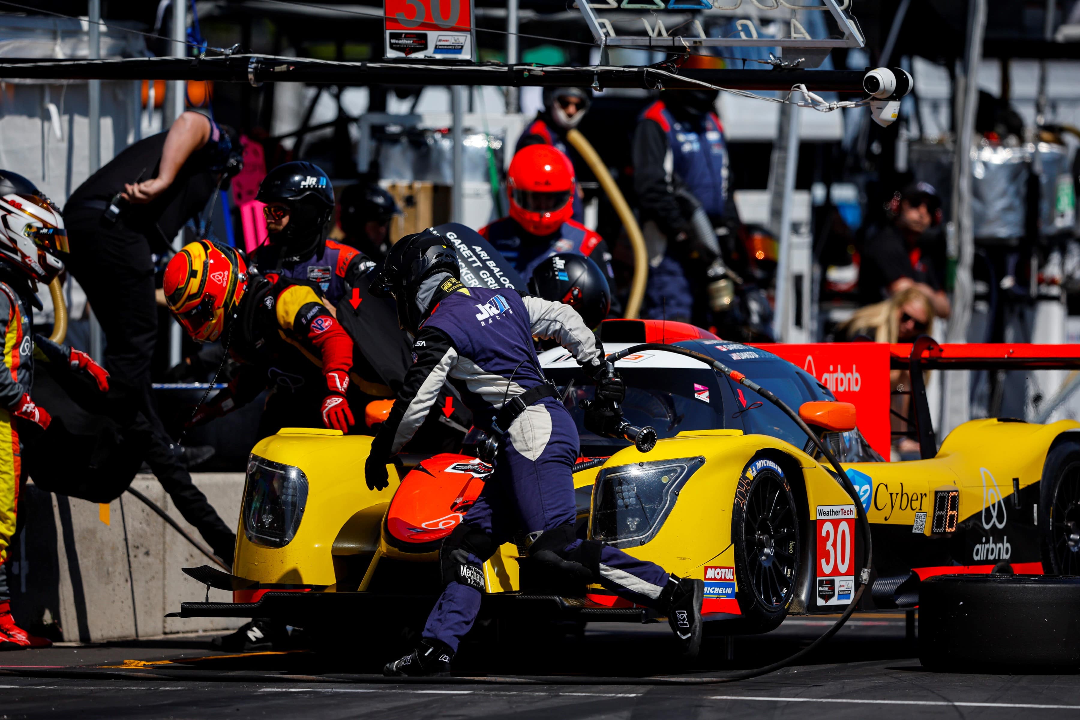 A racing pitcrew works on a car during a race.