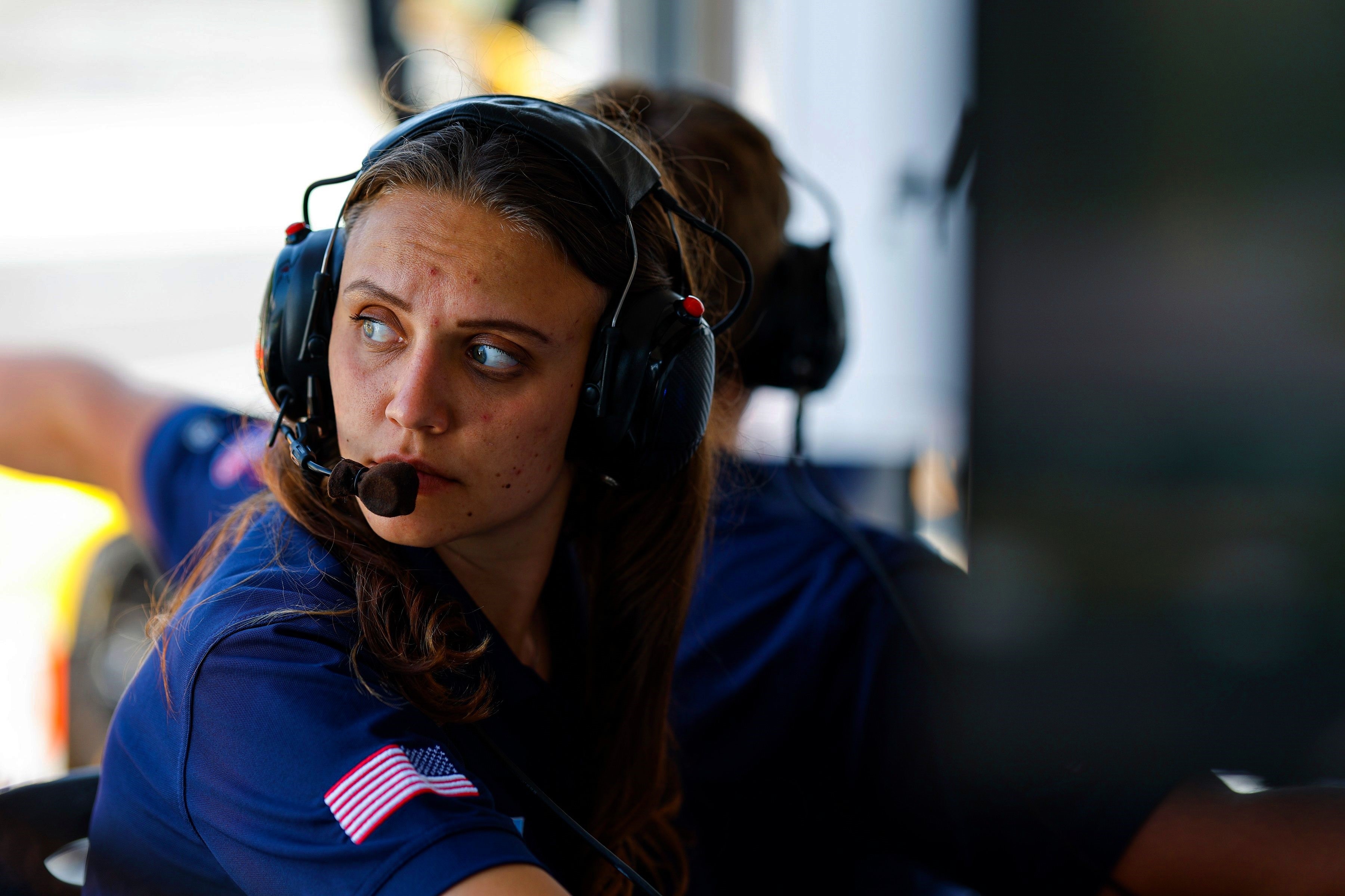 Jennea Katic wears a headset while monitoring a car race.