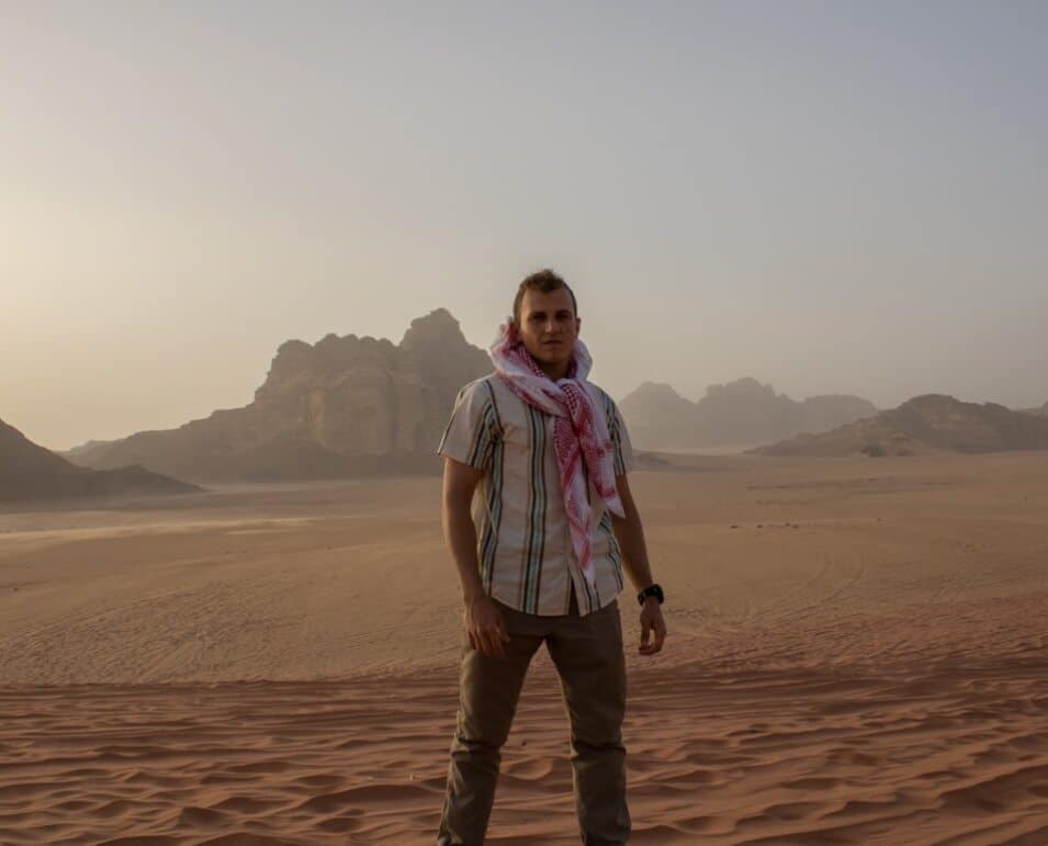A man poses in the desert.