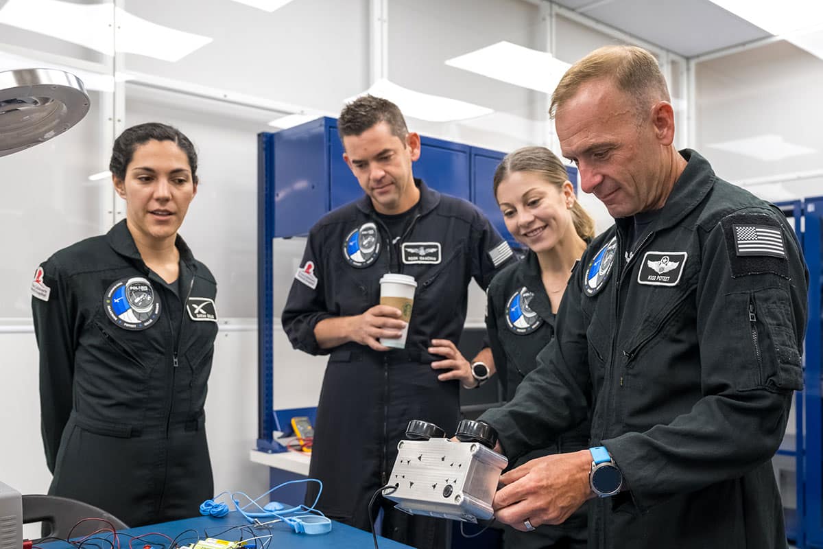 Polaris Dawn Mission Pilot Scott Poteet (right) inspects the LLAMAS camera unit.