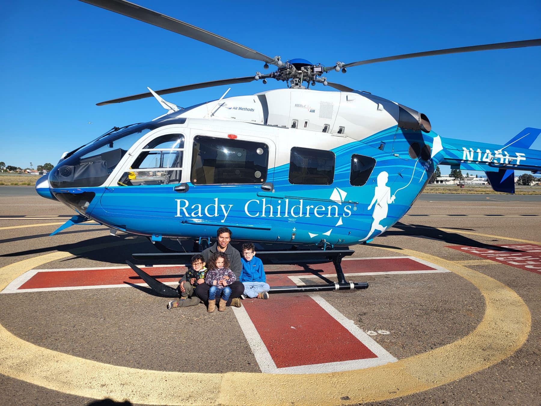 Juan Teodoro Paredes credits Embry‑Riddle’s Aviation Maintenance SkillBridge program with helping him find the a new and fulfilling career path. The U.S. Marine Corps veteran is pictured here with three of his children and one of the helicopters he maintains. (Photo: Embry‑Riddle/Andrew Jump)