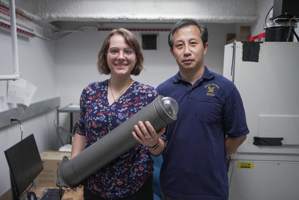 Dr. Alan Liu (right) poses with Ph.D. student Adriana Feener, who is holding an imager like the ones that will be buit to examine the Earth's upper atmosphere. (Photo: Embry‑Riddle/Bernard Wilchusky)