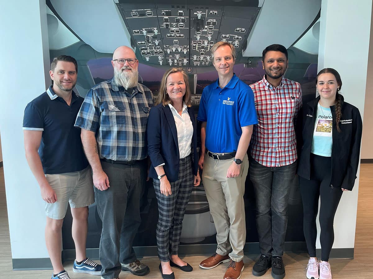 NASA funding is supporting an Embry‑Riddle team researching ways to reinforce positive human performance on the flight deck. The team includes (from left to right) graduate students Lucas Epperson and Joseph O’Brien; Kristy Kiernan, associate director of the Boeing Center for Aviation and Aerospace Safety; Andrew Schneider, assistant professor in the College of Aviation; Ph.D. student Joel Samu; and undergraduate student Evelyn Itzkowitz. (Photo: Embry‑Riddle/Melanie Stawicki Azam)