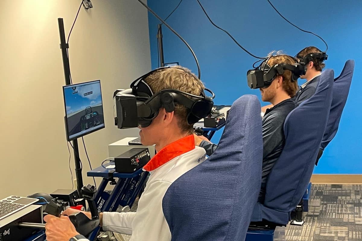 Professional race car drivers (from left to right) Mark Wilkins, Mason Filippi and Harry Gottsacker test their aviation skills using simulators at Embry‑Riddle Aeronautical University. (Photo: Embry Riddle/Melanie Stawicki Azam)